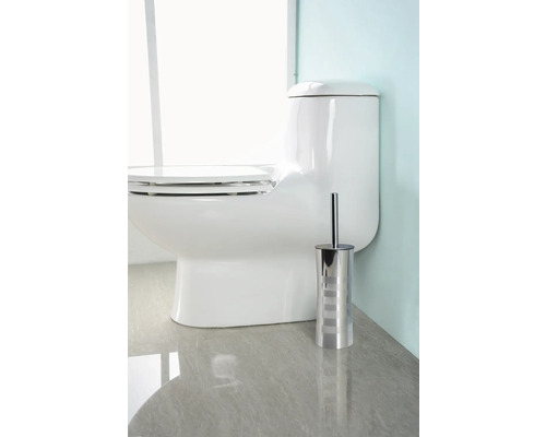 Vit stående toalett med toalettborste i metall