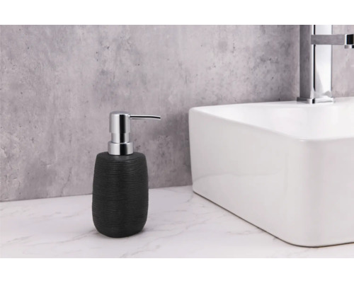 Svart tvålpump bredvid ett vitt handfat