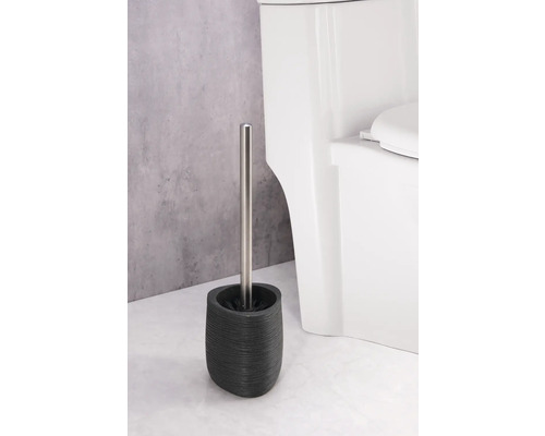 Toalettborste med hållare av stengods och rostfritt stålhandtag bredvid en toalett