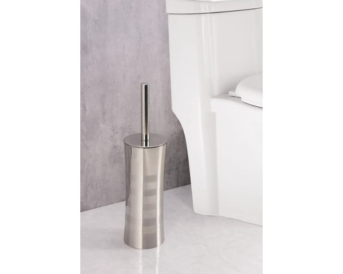 Toalettborste av metall med hållare bredvid toalett