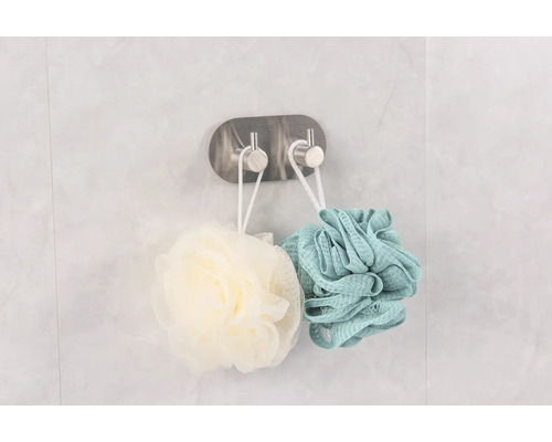 Två duschsvampar hänger på en krok för badrumsförvaring.