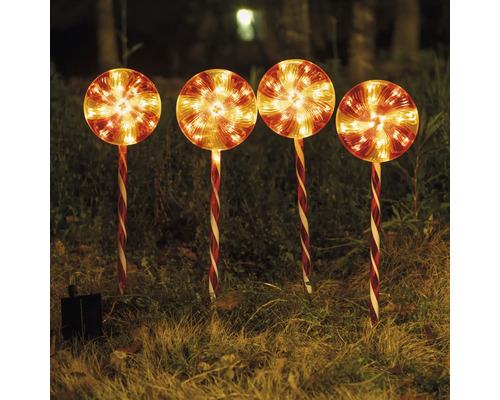 Fyra lysande solcellsdrivna klubbor som trädgårdsdekoration i gräset