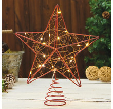 Stjärnformad trädtopp med belysning på ett bord