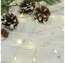 Dekorativ ljusslinga med kottar och pärlor på ljus bakgrund