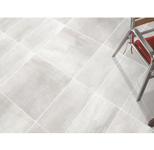 Ljust klinkergolv med stolsben i bilden