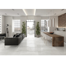 Ljust vardagsrum med svart lädersoffa, matbord och stora fönster