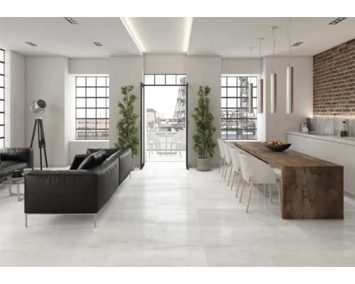 Ljust vardagsrum med svart lädersoffa, matbord och stora fönster