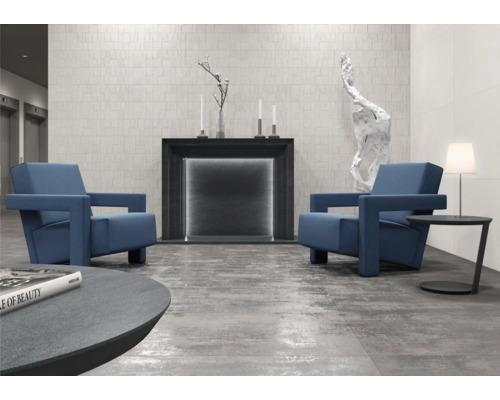 Vardagsrum med två fåtöljer, öppen spis och dekoration på ett klinkergolv