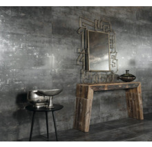 Miljö med grå väggplattor, spegel, träbord och dekoration