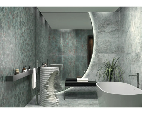 Ljust badrum med mosaikvägg, handfat och fristående badkar.