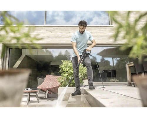 Man rengör terrass med högtryckstvätt