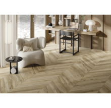 Interiör med trägolv i fiskbensmönster, skrivbord och fåtölj