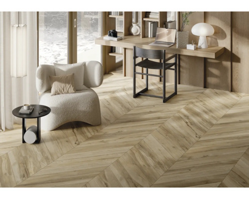 Interiör med trägolv i fiskbensmönster, skrivbord och fåtölj