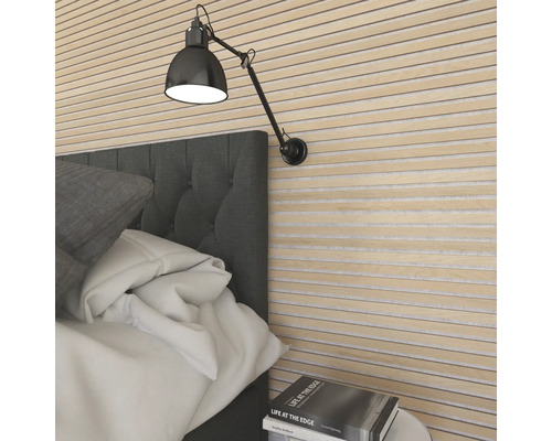 Sovrum med väggpaneler, sängbord och justerbar vägglampa