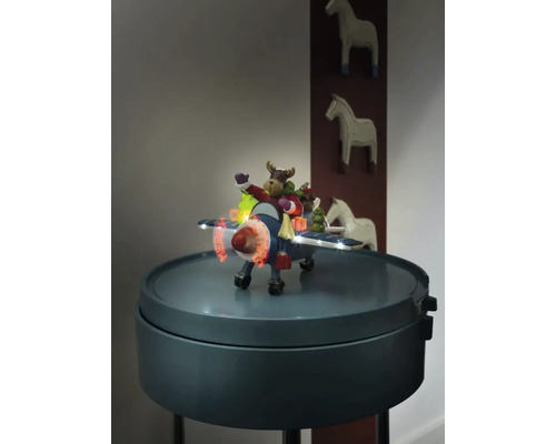 Dekorativt flygplan med älgfigur och belysning på ett sidobord