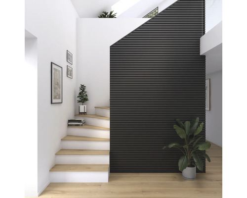 Ljus hall med trätrappa, krukväxter och väggpaneler