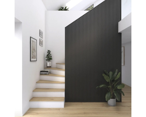 Ljus entré med trappa, väggpaneler och krukväxter.