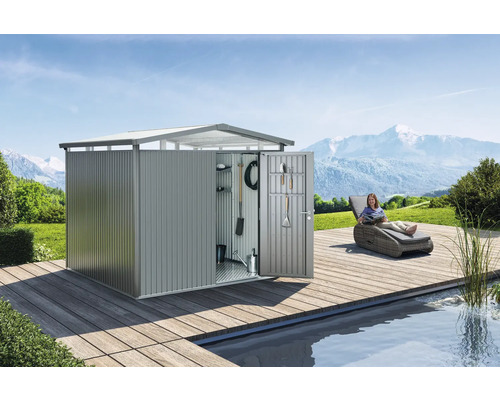 Metallträdgårdsskåp med öppen dörr, verktyg och en kvinna på en solstol bredvid en damm