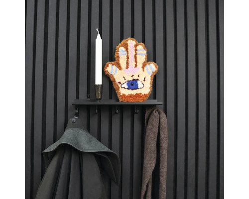 Vägghängare med kläder, ljus och väggdekoration i form av en hand med ett öga