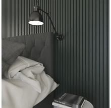 Sovrum med säng, sängbord, vägglampa och väggpaneler