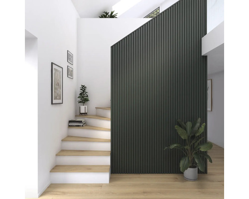 Ljus hall med trappa, väggpaneler och krukväxter