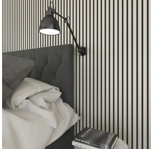 Sovrum med vägglampa, säng och sängbord