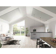 Ljust vardagsrum med akustikpaneler i taket, soffa, kök och matplats.