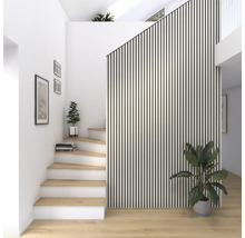 Ljust rum med trappa, trätrappsteg, krukväxter och väggpaneler i ribbstickad stil.