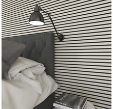 Sovrum med säng, sänglampa och randig vägg