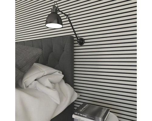 Sovrum med säng, lampa och väggbeklädnad i horisontella ränder