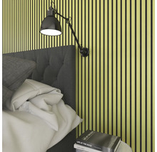 Sovrum med väggpaneler, säng, läslampa och sängbord