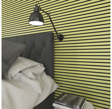 Sovrum med akustikpaneler på väggen, säng och lampa