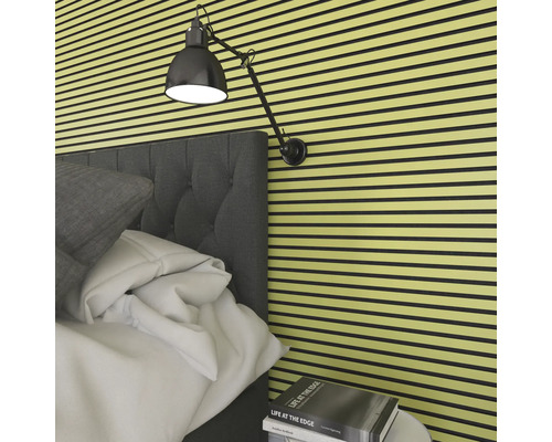 Sovrum med akustikpaneler på väggen, säng och lampa