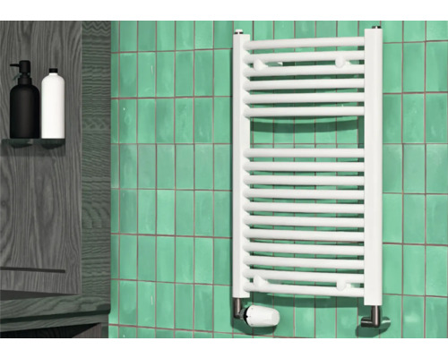 Badrum med en vit radiator, kakelvägg och två tvålpumpar