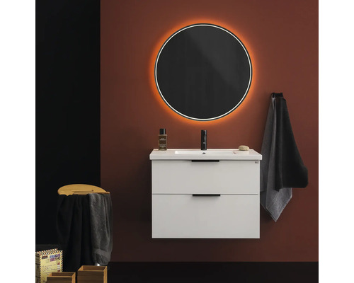 Modernt badrum med vitt tvättställsskåp, rund spegel med belysning och handdukar