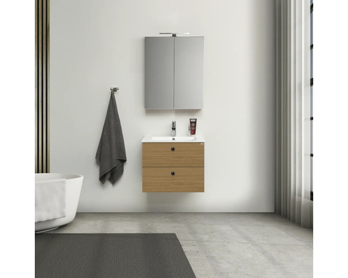 Badrum med tvättställsskåp, spegelskåp, handduk och badkar