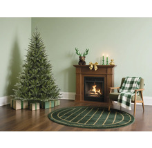 Vardagsrum med julgran, öppen spis och fåtölj för festlig atmosfär