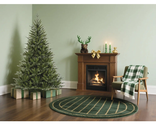 Vardagsrum med julgran, öppen spis och fåtölj för festlig atmosfär