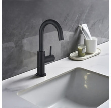 Svart tvättställsblandare bredvid ett handfat i ett badrum.