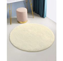 Rund matta, pall, bord och gardin skapar en ljus och organiserad rumsmiljö.