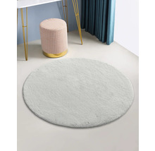 Rund ljusfärgad matta i ett rum med pall och bord.