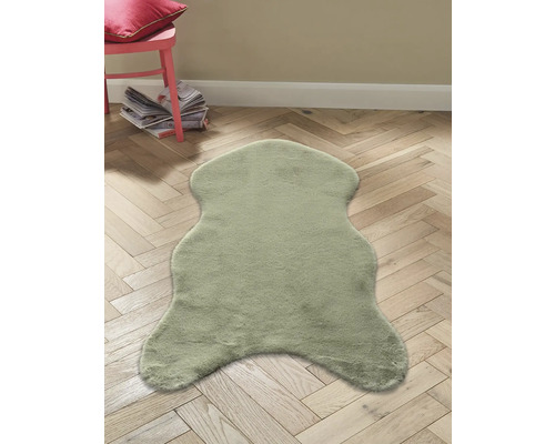 Dekorativ fäll på trägolv med stol och tidskrifter i bakgrunden