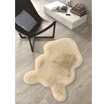 Dekorativ matta i fårskinnsimitation bredvid en stol och ett bord