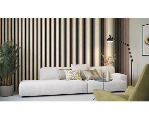 Vardagsrum med träpanelvägg, soffa, golvlampa och krukväxt.