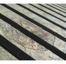 Närbild av naturstenspaneler med mörka accenter för väggdekoration