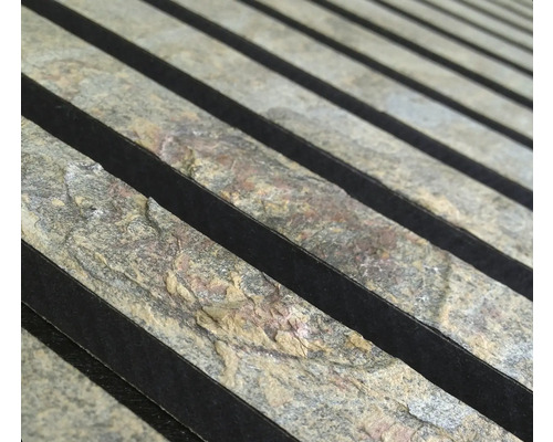 Närbild av naturstenspaneler med mörka accenter för väggdekoration