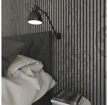 Sovrum med säng, vägglampa och väggpaneler