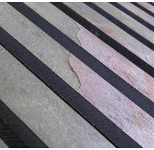 Närbild av en akustisk panelyta med träribbor