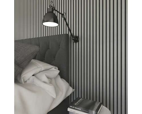 Sovrum med säng, vägglampa och nattduksbord med bok