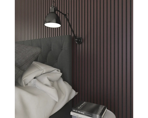 Sovrum med säng, vägglampa och väggpaneler